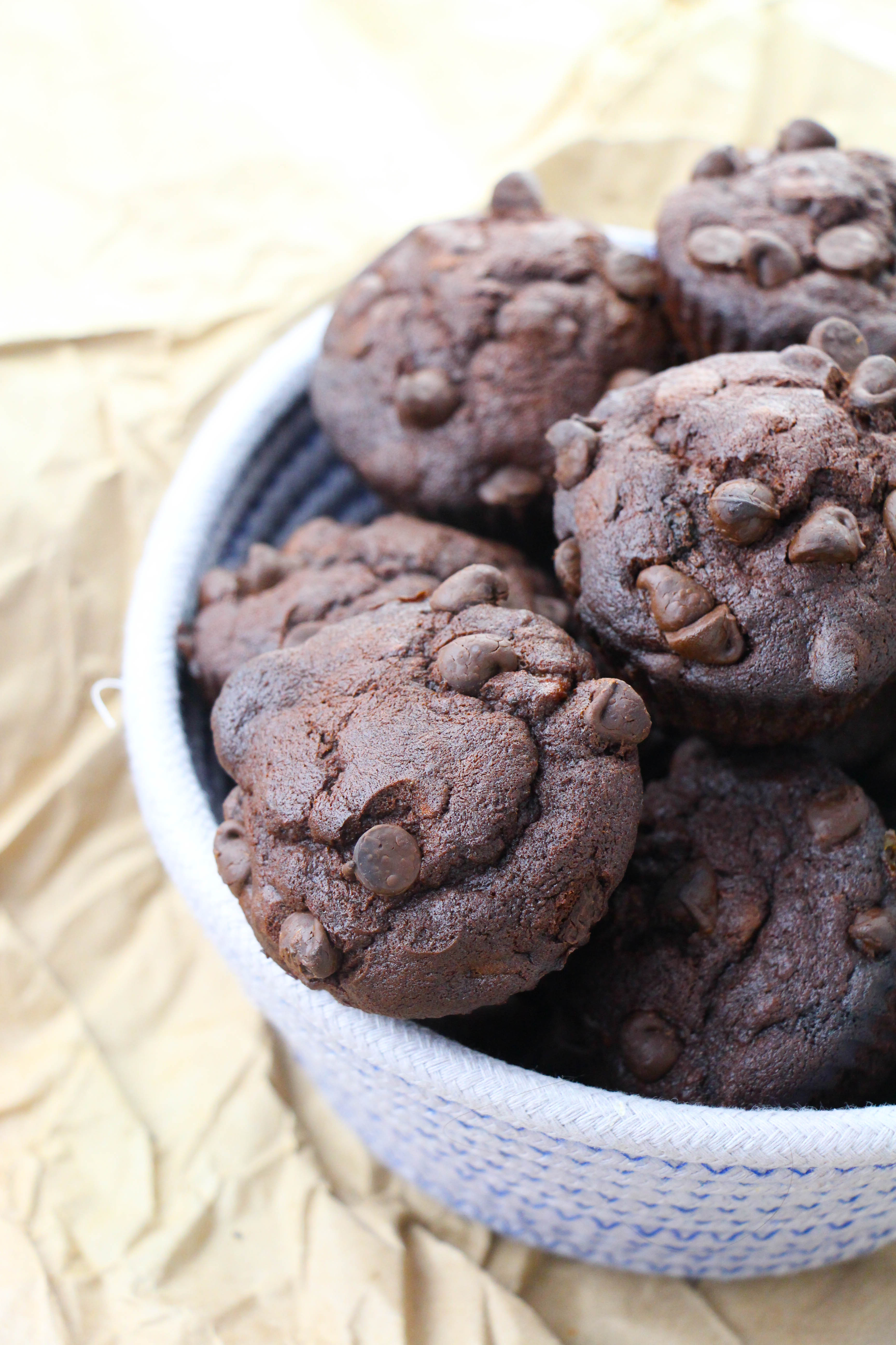 Baked Double Chocolate Banana Muffins in a white bowl on table 
